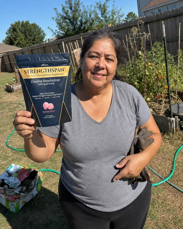 Person holding a Strengthspan bag in a backyard vegetable garden